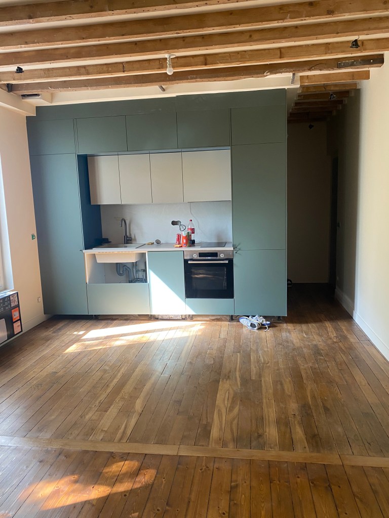 Avant et après rénovation d’un salon avec parquet en bois et cuisine ouverte moderne